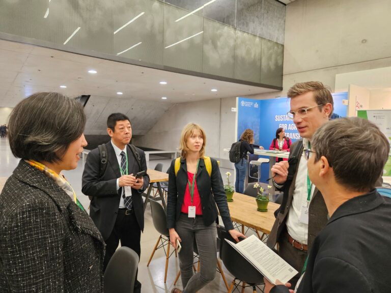 Ms. LIN Huifang and Mr. WANG Geng from FECC (left) speak with GFA Deputy Program Director Malte Müller (second right) at GFFA 2025